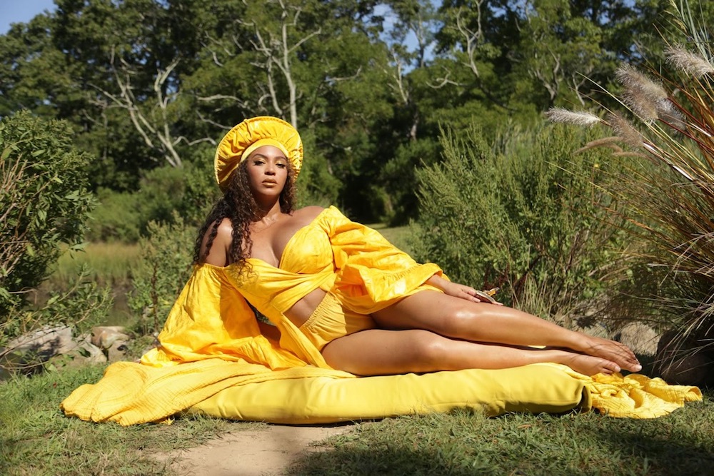 law of attraction. Image of a beautiful woman wearing yellow, basking in the sun and enjoying the benefits of the law of attraction