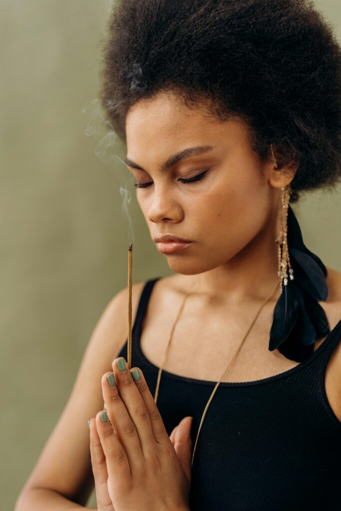 false light teachings, picture of attractive black woman praying with incense in her hands