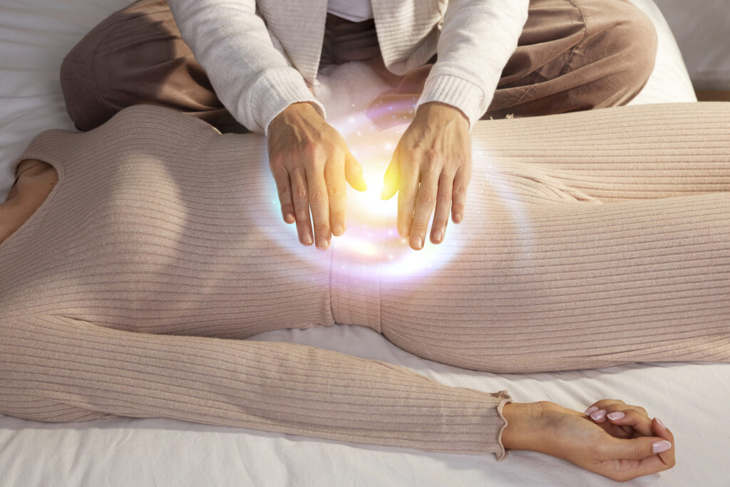 High angle view of a woman receiving energy healing, with a glowing light around the healer's hands, symbolizing spiritual healing and balance